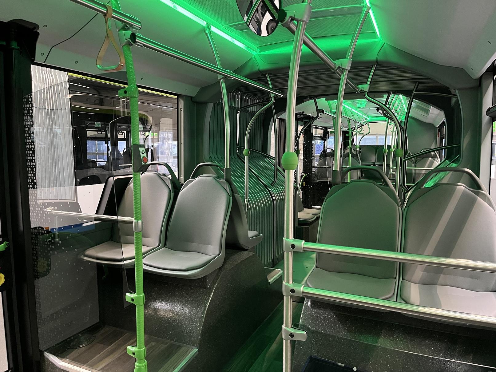 Innenraum eines eCitaro-Gelenkbusses mit grüner Beleuchtung
